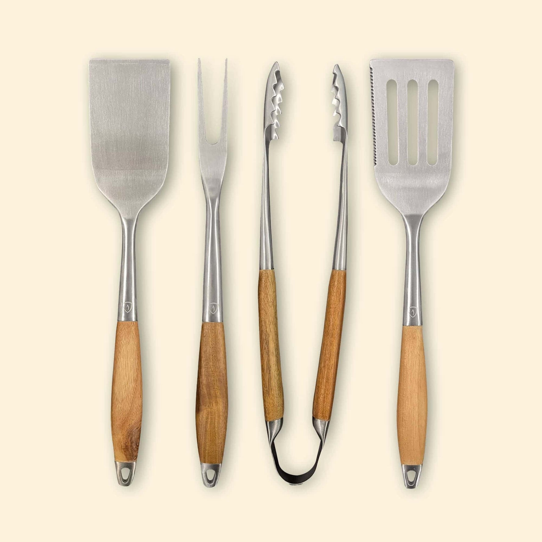 Set de quatre ustensiles de cuisson en inox avec manches en bois, comprenant deux spatules, une pince et une fourchette, présentés de face alignés verticalement.