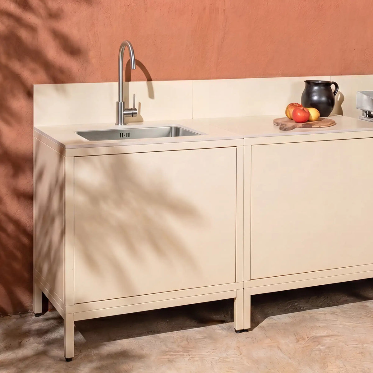 Cocina de exterior Pilotis blanco crema con módulo de fregadero, encimera de cerámica clara y plancha
::visuel:creme