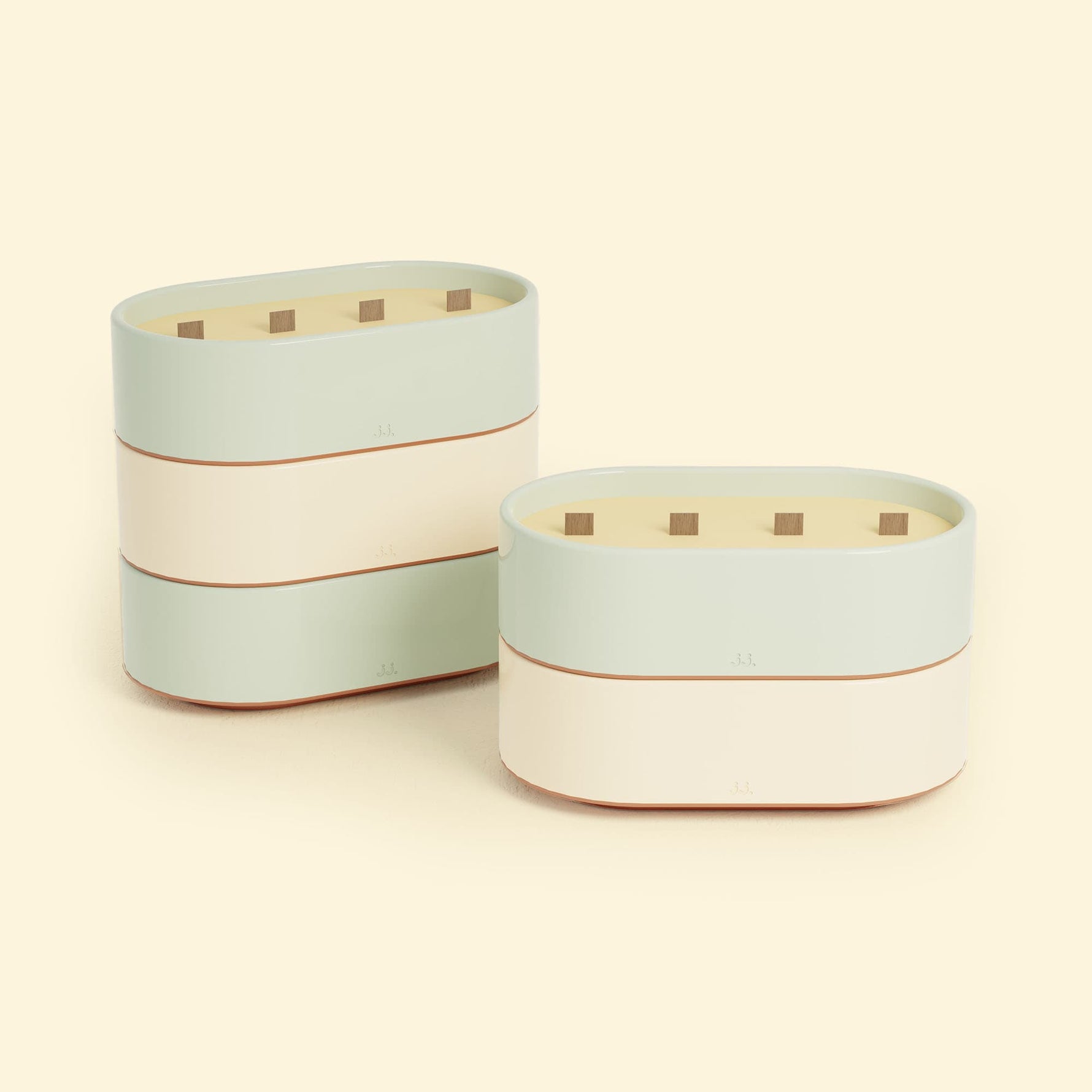 Bougies Totem L Vert d’eau – Citronnelle & Eucalyptus et Beige ivoire – Citronnelle & Citron, deux grandes bougies ovales à triple mèche en bois, posées sur un fond beige clair.