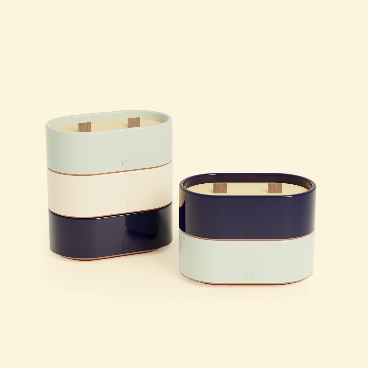 Bougies Totem S Bleu marine – Citronnelle & Sel de mer et Vert d’eau – Citronnelle & Eucalyptus, deux bougies ovales à double mèche en bois, posées sur un fond beige clair. 