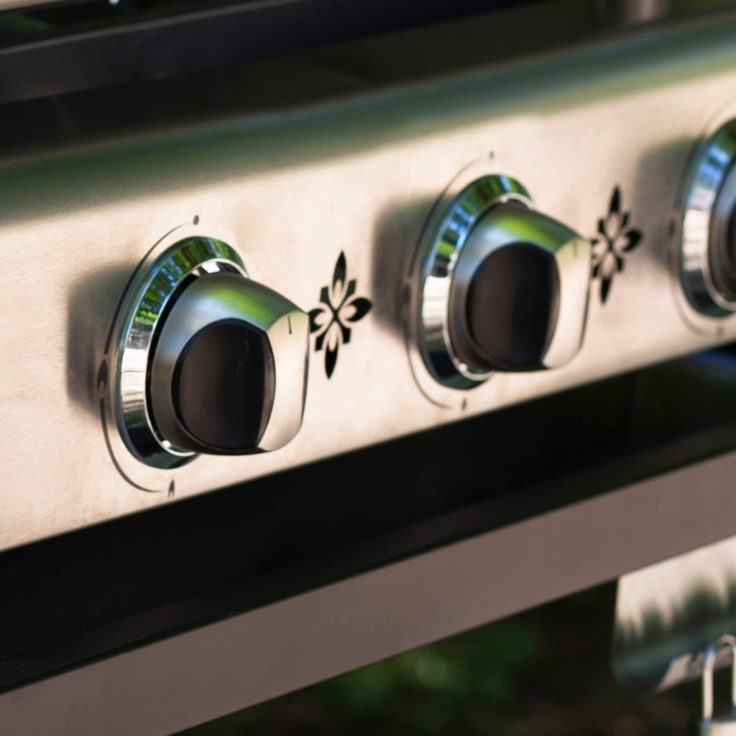 Gros plan sur les boutons de réglage en inox de la plancha Vivaplancha, avec reflets de lumière naturelle.