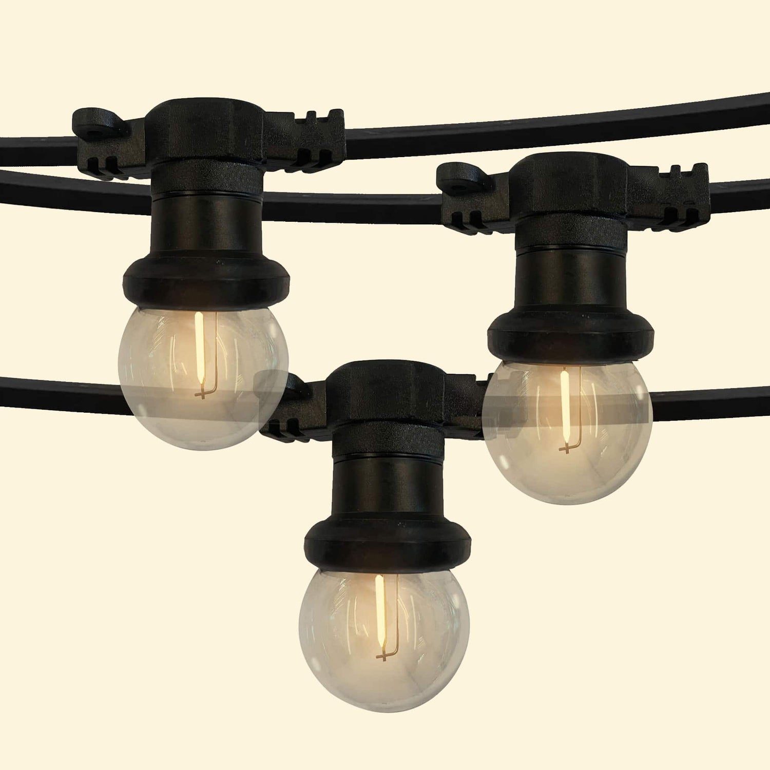 Guirlande lumineuse d’extérieur avec ampoules rondes transparentes à filament LED, montées sur un câble noir résistant, parfaite pour éclairer et décorer terrasses, pergolas ou jardins.