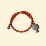 Tuyau de gaz rouge avec détendeur vert et manomètre intégré, compatible installation gaz Suisse, présenté sur fond uni clair.