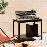 Plancha gaz Vivaplancha Pimientos 3 feux en inox, installée sur une desserte extérieure noire, en cuisson avec des légumes grillés.